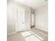 A bright bedroom with neutral walls, carpeting, and a white door at 17648 W Pierson St, Goodyear, AZ 85395