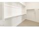 Spacious walk-in closet with ample shelving and neutral carpeting at 17648 W Pierson St, Goodyear, AZ 85395
