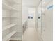 Bright, modern bathroom with glass shower, open shelving, grey double vanity, and view of a bedroom at 17737 W Elm St, Goodyear, AZ 85395