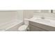 Bathroom with a grey vanity, toilet, and tiled shower and bathtub at 17737 W Elm St, Goodyear, AZ 85395