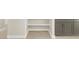 Tile floor in bathroom, with grey vanity with white countertop, and open storage and shelving at 17737 W Elm St, Goodyear, AZ 85395