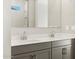 Modern bathroom with gray double vanity, white countertop, and tiled shower with glass door at 17737 W Elm St, Goodyear, AZ 85395