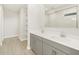 Modern bathroom featuring a double sink vanity, gray cabinets, open shelving, and a glass shower at 17737 W Elm St, Goodyear, AZ 85395