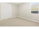 A well-lit bedroom featuring neutral carpeting, a window, and a closet at 17737 W Elm St, Goodyear, AZ 85395