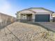 This home's exterior view features low-maintenance desert landscaping and a convenient two-car garage at 17737 W Elm St, Goodyear, AZ 85395