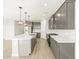 A spacious kitchen featuring stainless steel appliances, sleek gray cabinets, and modern lighting at 17737 W Elm St, Goodyear, AZ 85395