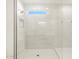 Modern shower with a glass door, white tiling, and niche for products at 17737 W Elm St, Goodyear, AZ 85395