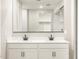 Bathroom showcasing double sinks, a large mirror, and a glimpse into the walk-in shower at 17749 W Elm St, Goodyear, AZ 85395
