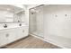 Modern bathroom with double sink vanity, marble walk-in shower, and tile flooring at 17749 W Elm St, Goodyear, AZ 85395