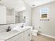 Modern bathroom with dual sinks, white cabinetry, and a tile floor at 17749 W Elm St, Goodyear, AZ 85395
