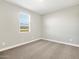 A bright bedroom features neutral carpet and a window with a view of the neighborhood at 17749 W Elm St, Goodyear, AZ 85395