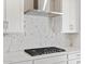 Kitchen area showcasing stainless steel range hood and gas cooktop at 17749 W Elm St, Goodyear, AZ 85395
