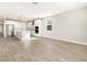 Open-concept living space with wood tile flooring and a modern kitchen with stainless steel appliances at 17749 W Elm St, Goodyear, AZ 85395