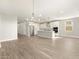 Open-concept living space with wood-look tile, seamlessly connecting the living area to the modern kitchen at 17749 W Elm St, Goodyear, AZ 85395