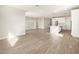 Open-concept living space with wood-look tile, connecting the living area and kitchen for modern living at 17749 W Elm St, Goodyear, AZ 85395