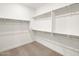 Walk-in closet with ample shelving and neutral carpeting, perfect for organization at 17749 W Elm St, Goodyear, AZ 85395