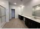 Bathroom showcases a long double vanity, walk-in glass shower, and sleek tile flooring at 47267 W Mellen Ln, Maricopa, AZ 85139