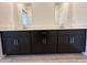 Modern bathroom vanity with double sinks, sleek black cabinets, and contemporary fixtures at 47267 W Mellen Ln, Maricopa, AZ 85139