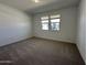 Sunlit bedroom with neutral carpet, creating a cozy and inviting atmosphere at 47267 W Mellen Ln, Maricopa, AZ 85139