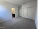 Light-filled bedroom featuring plush carpeting and an adjacent bathroom, providing comfort and convenience at 47267 W Mellen Ln, Maricopa, AZ 85139