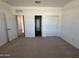 Spacious bedroom offering carpet flooring, a closet, and a view of the surrounding neighborhood at 47267 W Mellen Ln, Maricopa, AZ 85139