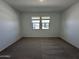 Bright, carpeted bedroom with ample natural light streaming in through the window at 47267 W Mellen Ln, Maricopa, AZ 85139
