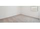 An empty bedroom has soft, neutral carpet and a bright window at 47267 W Mellen Ln, Maricopa, AZ 85139
