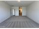 Large bedroom with carpet flooring, bright walls, and a glimpse into the home's hallway at 47267 W Mellen Ln, Maricopa, AZ 85139