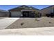 Inviting single-story home featuring a well-manicured gravel yard, attached garage, and classic architectural details at 47267 W Mellen Ln, Maricopa, AZ 85139