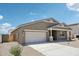 This single-story home features a two-car garage and simple desert landscaping at 47267 W Mellen Ln, Maricopa, AZ 85139