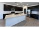 The kitchen features black cabinets, a white island, and stainless steel appliances at 47267 W Mellen Ln, Maricopa, AZ 85139