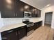 The kitchen features black cabinets, white countertops, a gas range, and stainless steel appliances at 47267 W Mellen Ln, Maricopa, AZ 85139