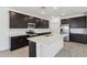 A spacious kitchen with an island, stainless steel appliances and dark wood cabinetry at 47267 W Mellen Ln, Maricopa, AZ 85139