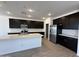 The kitchen features black cabinets, a white island, and stainless steel appliances at 47267 W Mellen Ln, Maricopa, AZ 85139