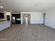 Open-concept living room flows into a modern kitchen with stainless steel appliances and tile flooring at 47267 W Mellen Ln, Maricopa, AZ 85139
