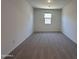 The living room is carpeted and has a window to let in natural light at 47267 W Mellen Ln, Maricopa, AZ 85139