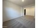 The living room is carpeted and is located adjacent to a room with wood-style flooring at 47267 W Mellen Ln, Maricopa, AZ 85139