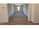 The living room is carpeted and has a window to let in natural light at 47267 W Mellen Ln, Maricopa, AZ 85139