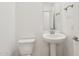 Well-lit powder room featuring a sleek pedestal sink and modern fixtures at 47267 W Mellen Ln, Maricopa, AZ 85139
