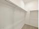 Walk-in closet with white shelving and neutral carpeting at 9120 N 174Th Ln, Waddell, AZ 85355