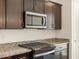 Close up of a modern kitchen with dark cabinets and granite countertops at 9120 N 174Th Ln, Waddell, AZ 85355
