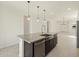 Kitchen island featuring granite countertops, stainless steel sink, and modern pendant lighting at 9120 N 174Th Ln, Waddell, AZ 85355