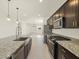Open kitchen with stainless steel appliances, granite countertops, and a view of the living area at 9120 N 174Th Ln, Waddell, AZ 85355