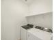 Functional laundry room with modern washer and dryer, and shelving at 9120 N 174Th Ln, Waddell, AZ 85355