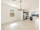 Bright living room with modern light fixtures, tile flooring, and an open concept layout to the kitchen at 9120 N 174Th Ln, Waddell, AZ 85355