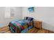 Bedroom with hardwood floors, white walls, and a colorful quilt on the bed at 11899 N Spearfish St, Surprise, AZ 85388
