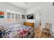 Bedroom with a colorful quilt, wood floors, a shuttered window, dresser and television at 11899 N Spearfish St, Surprise, AZ 85388