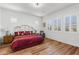 Comfortable bedroom with a wrought iron bed frame, shuttered windows, and laminate wood flooring at 11899 N Spearfish St, Surprise, AZ 85388