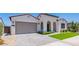 Charming single-story home features a neutral color palette, tile roof, arched entryway, and a well-maintained front yard at 11899 N Spearfish St, Surprise, AZ 85388
