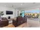 Inviting living room with a leather sectional, large television, and seamless access to the outdoor patio through sliding doors at 11899 N Spearfish St, Surprise, AZ 85388